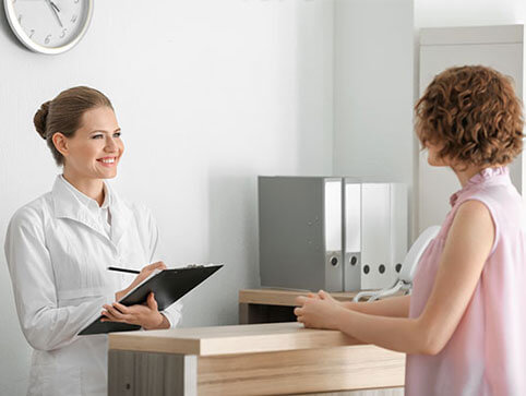 Patient at front desk completing paperwork 